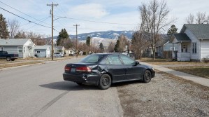 sedan with crushed rear quarter panel damage stopped on residential street