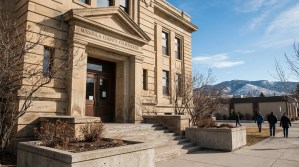 Missoula County Courthouse exterior entrance with pedestrians and mountain backdrop